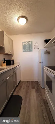a kitchen with a sink a microwave and cabinets