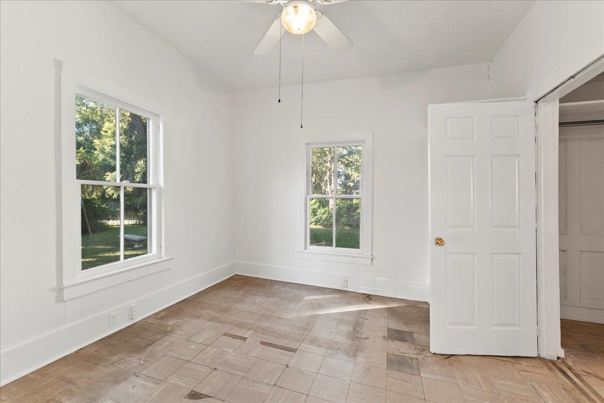 10 Clark Street St. Augustine, FL 32084 - Photo 16 of 44 an empty room with windows and chandelier fan