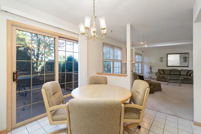 a living room with furniture a chandelier and a large window