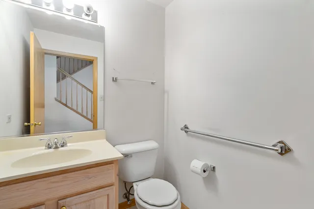 a bathroom with a granite countertop sink mirror vanity and toilet
