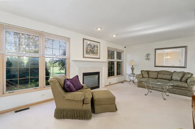 a living room with furniture a large window and a fireplace