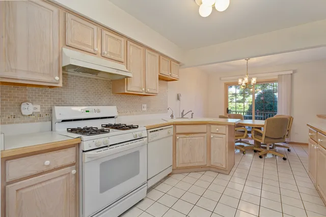 a kitchen with cabinets appliances a sink and a window