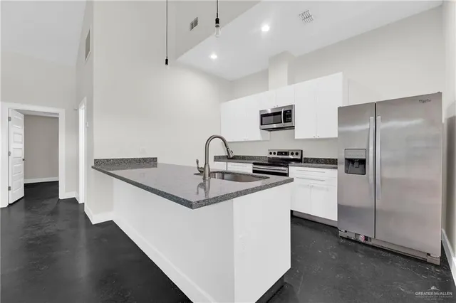a kitchen with stainless steel appliances a sink stove and refrigerator