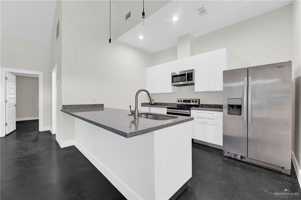 308 North 17th Street, Unit B McAllen, TX 78501 - Photo 5 of 19 a kitchen with stainless steel appliances a sink stove and refrigerator
