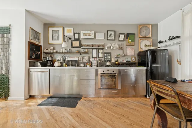 a kitchen with stainless steel appliances kitchen island granite countertop a refrigerator and a stove top oven