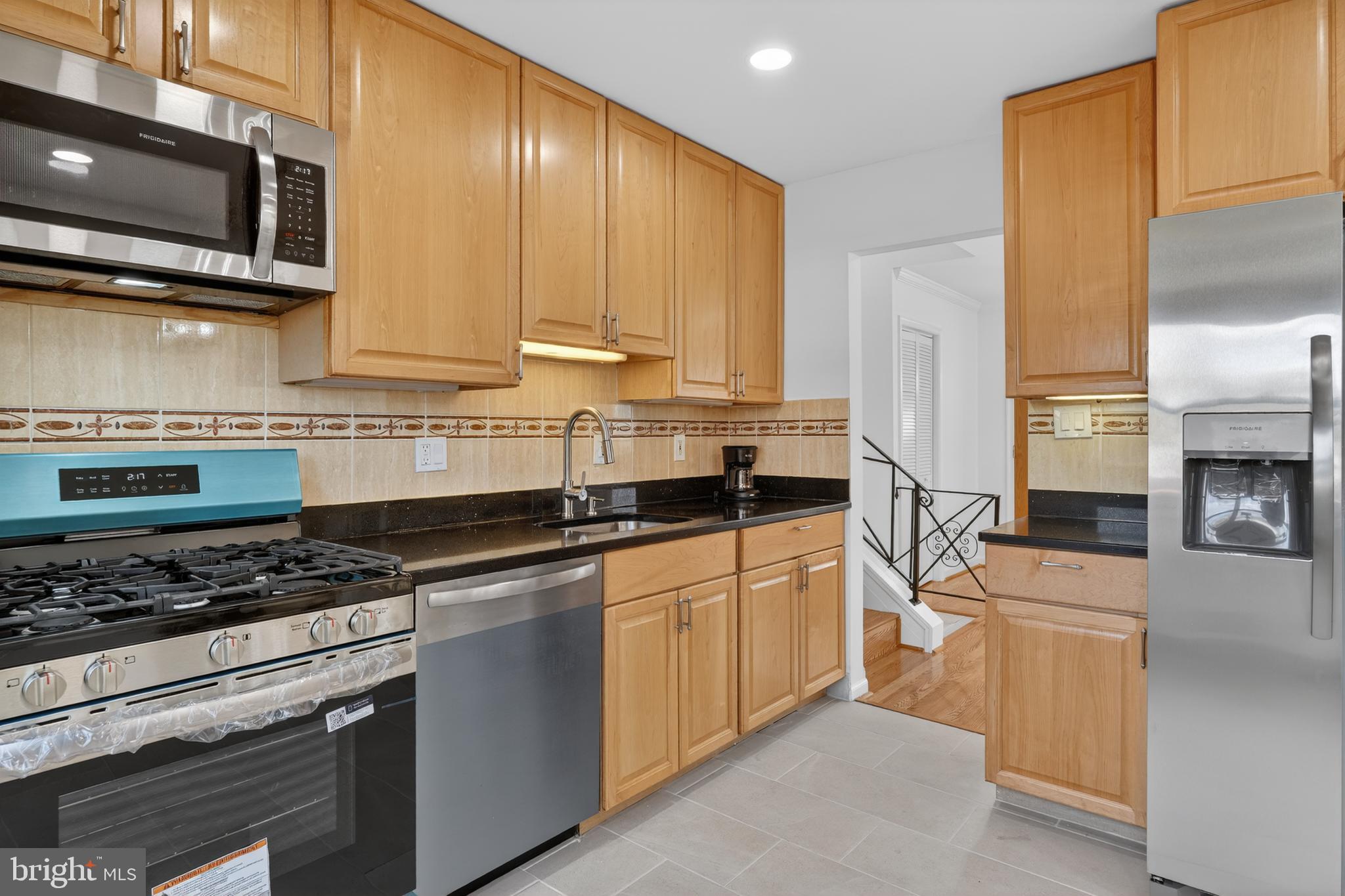 1132 Loxford Terrace Silver Spring, MD 20901 - Photo 11 of 30 a kitchen with stainless steel appliances granite countertop a stove a sink and a refrigerator