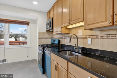 a kitchen with granite countertop a sink and cabinets