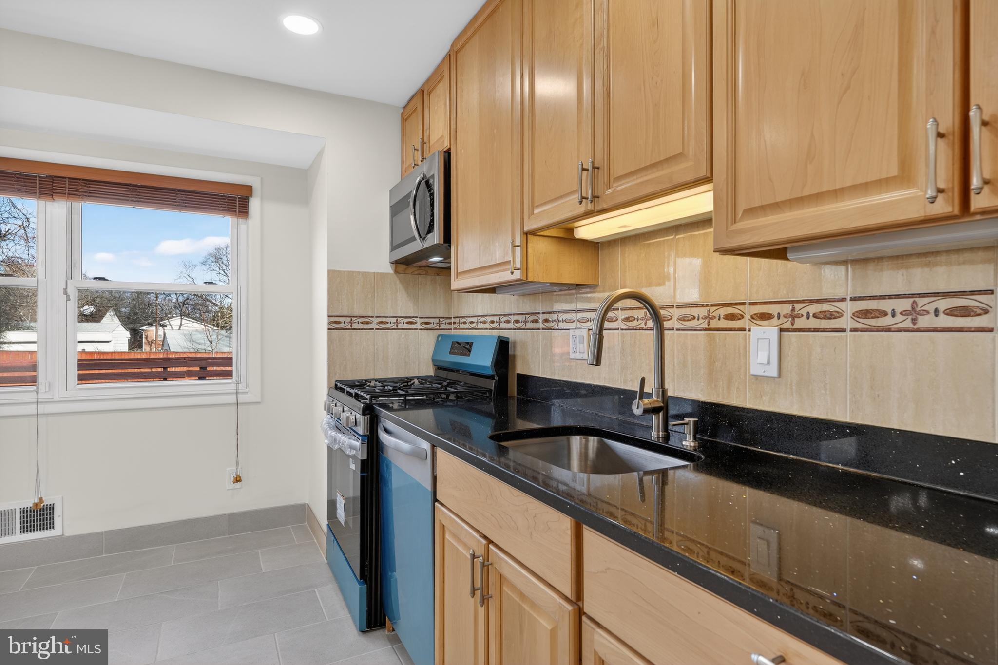 1132 Loxford Terrace Silver Spring, MD 20901 - Photo 9 of 30 a kitchen with granite countertop a sink and cabinets