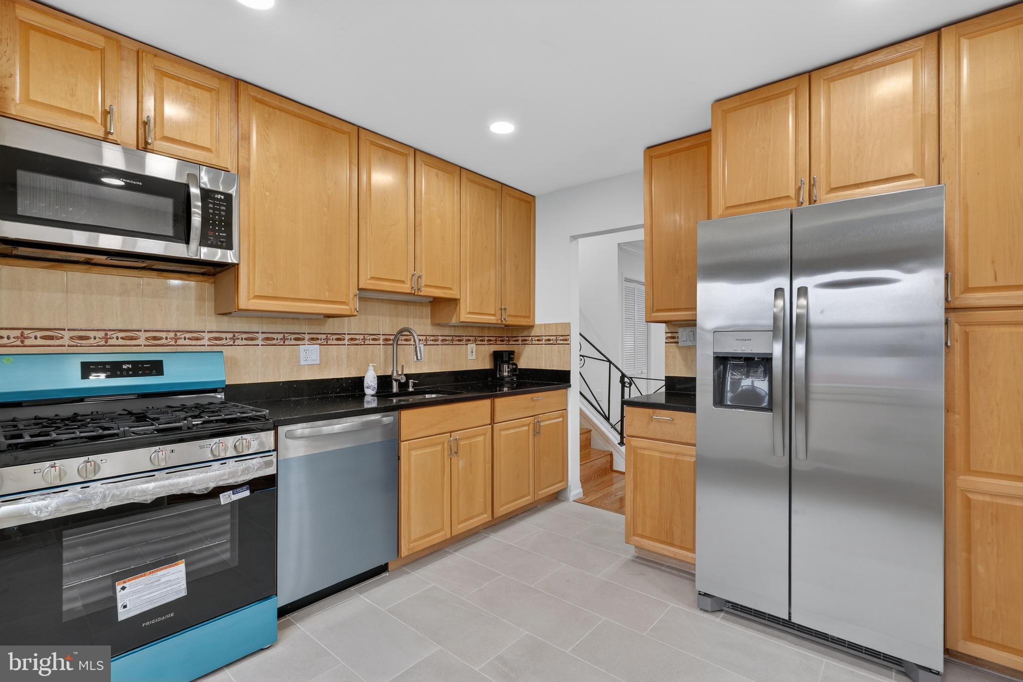 1132 Loxford Terrace Silver Spring, MD 20901 - Photo 10 of 30 a kitchen with stainless steel appliances granite countertop a refrigerator a stove a sink and a microwave