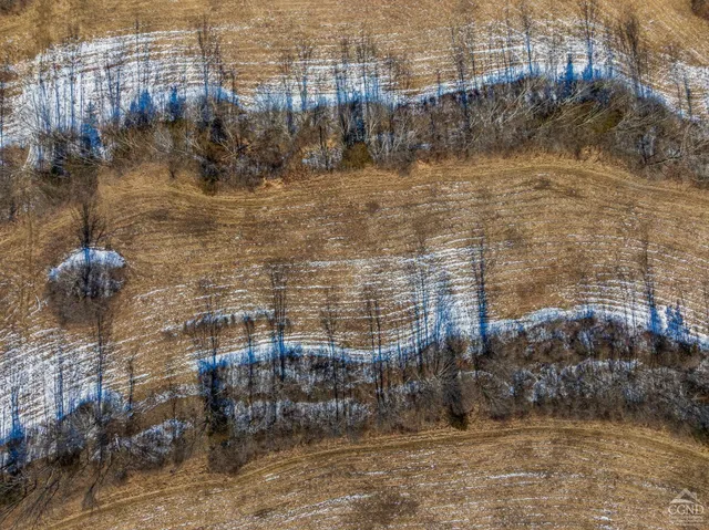 an aerial view of house with yard and mountain view in back