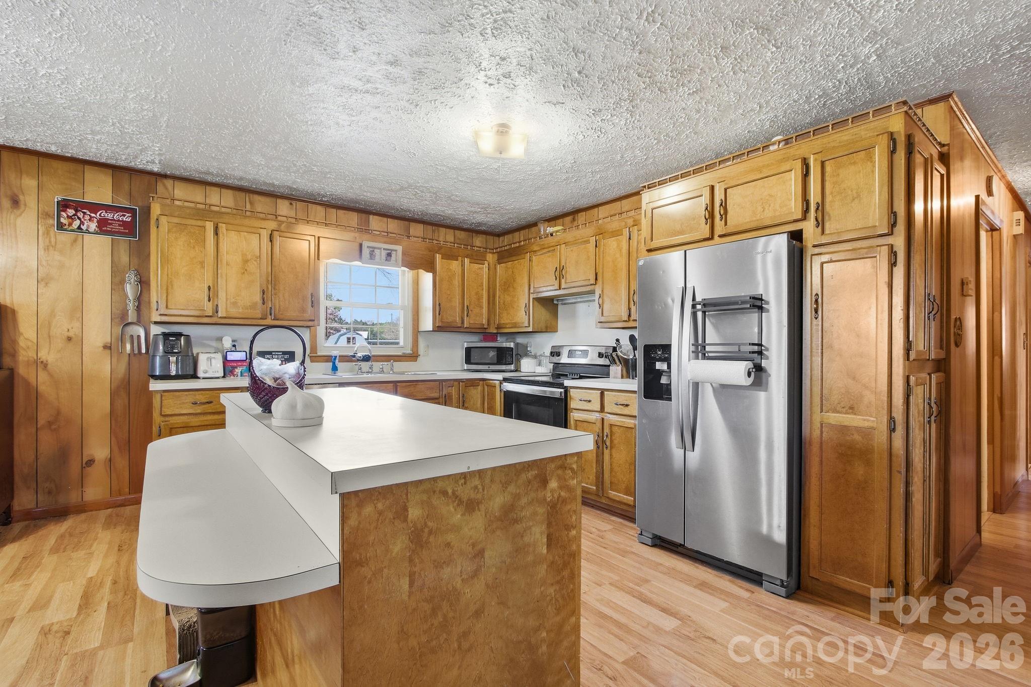 3266 Coble Dairy Road Hudson, NC 28638 - Photo 12 of 37 a kitchen with stainless steel appliances granite countertop a refrigerator a sink dishwasher and a dining table with garden view