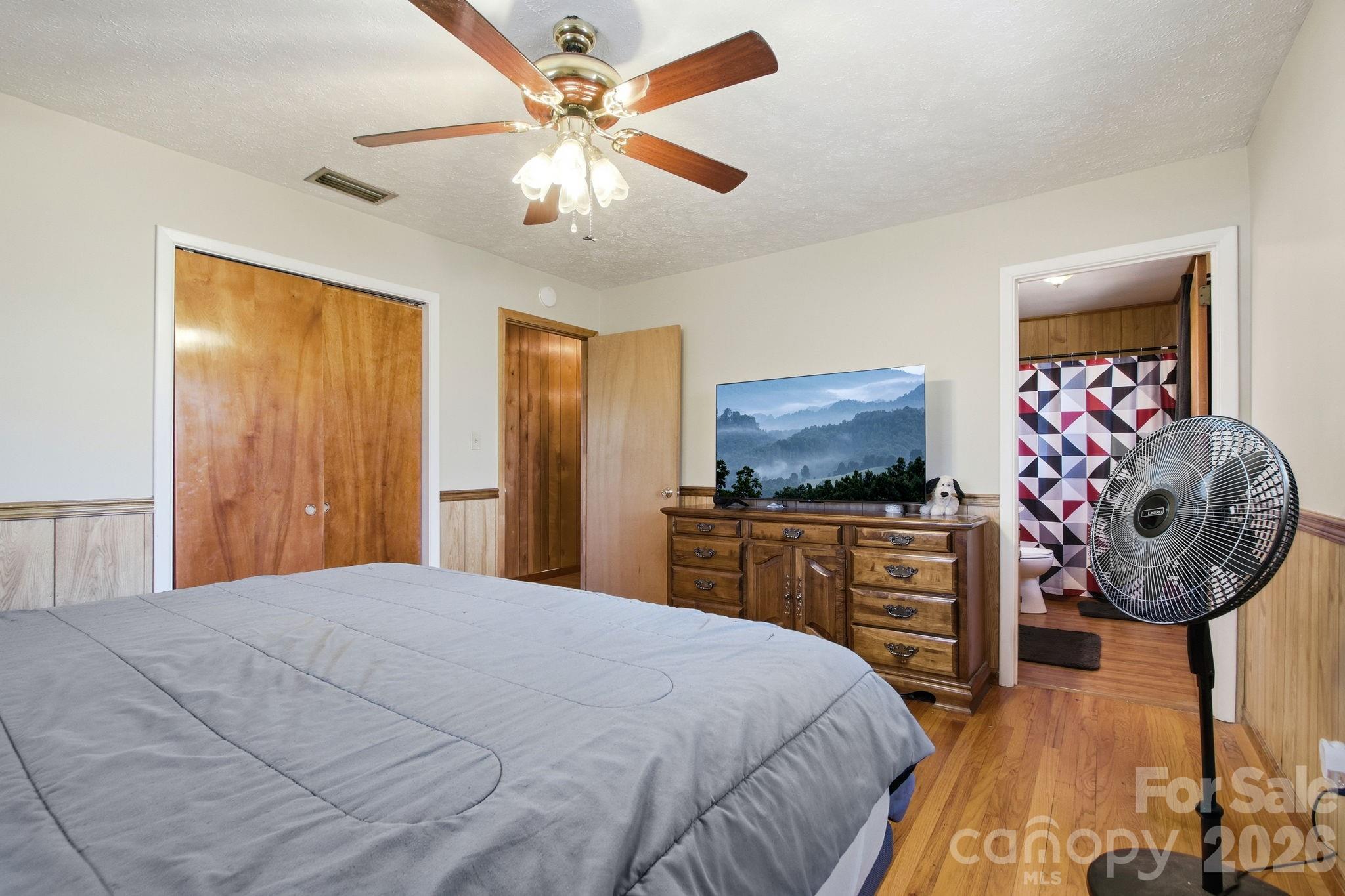 3266 Coble Dairy Road Hudson, NC 28638 - Photo 23 of 37 a bedroom with a bed and a chandelier