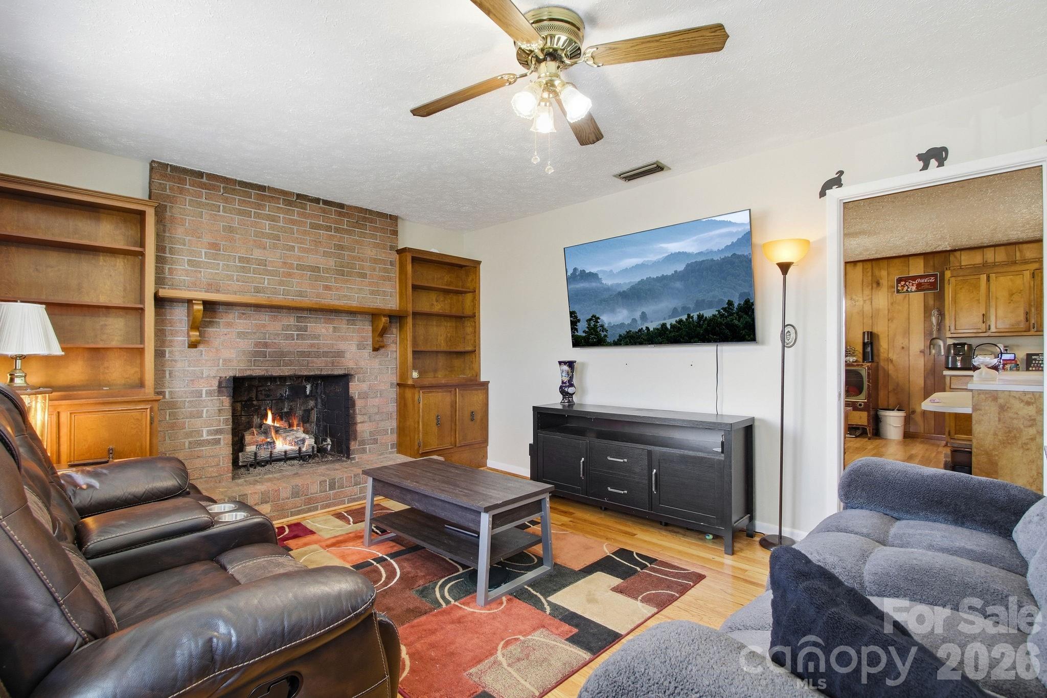 3266 Coble Dairy Road Hudson, NC 28638 - Photo 5 of 37 a living room with furniture a flat screen tv and a fireplace