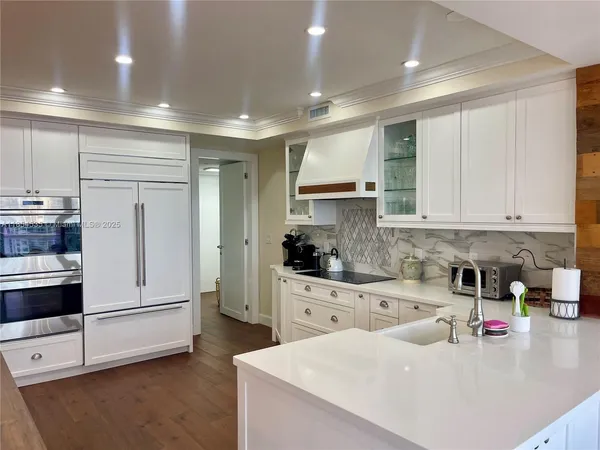 a kitchen with a sink a stove and wooden floor