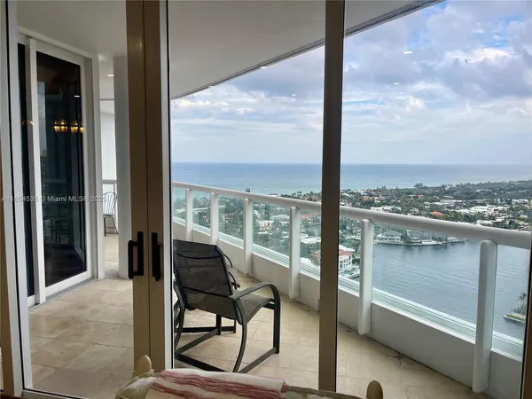 a view of a balcony with chairs and a floor to ceiling window