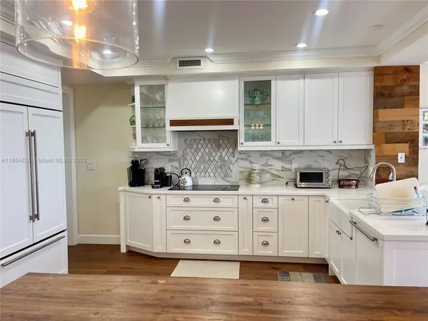 a kitchen with stainless steel appliances granite countertop a stove a sink and white cabinets