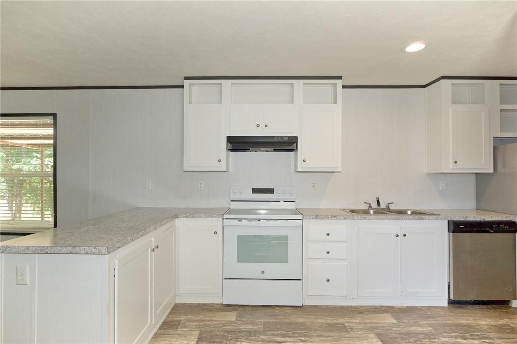 60 Tecumseh Road Valley View, TX 76272 - Photo 9 of 20 Kitchen featuring white cabinetry, white electric range, stainless steel dishwasher, double basin sink, and wood-finish flooring