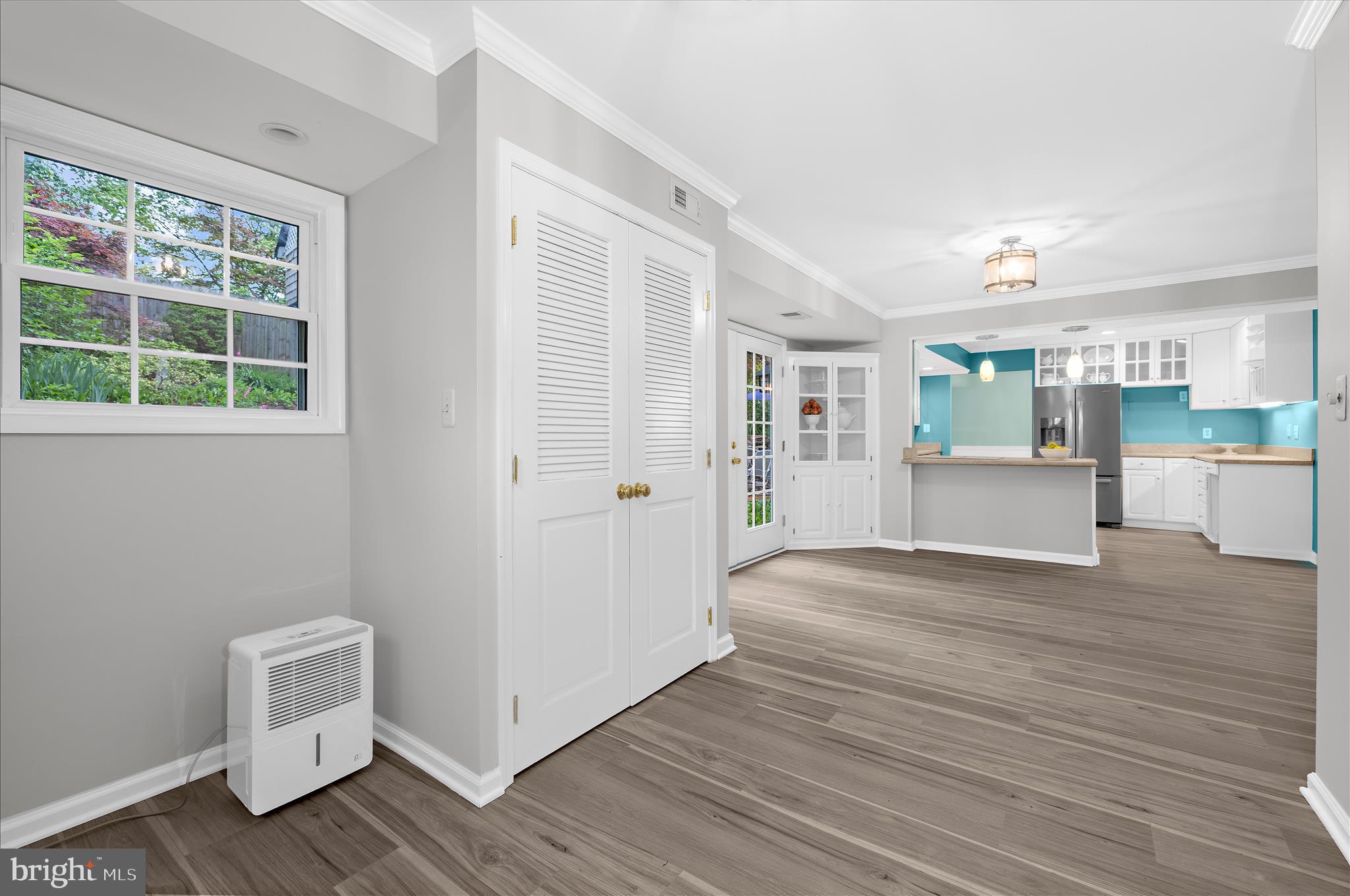 1126 Neptune Place Annapolis, MD 21409 - Photo 25 of 79 a view of a kitchen and an empty room with wooden floor and a window