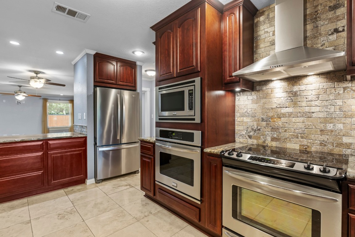 3745 Canyon Heights Road Belton, TX 76513 - Photo 8 of 29 a kitchen with granite countertop wooden cabinets and stainless steel appliances