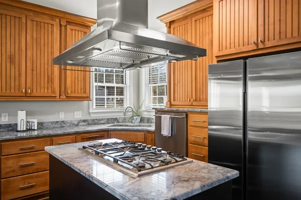 a kitchen with stainless steel appliances granite countertop a sink a stove and refrigerator
