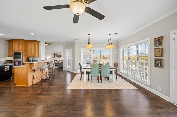 a dining room with furniture a chandelier and wooden floor