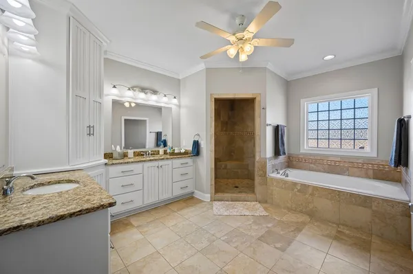 a large spacious bathroom with a granite countertop tub sink shower and mirror