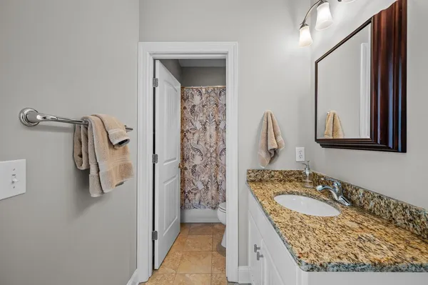 a bathroom with a granite countertop sink a mirror and shower