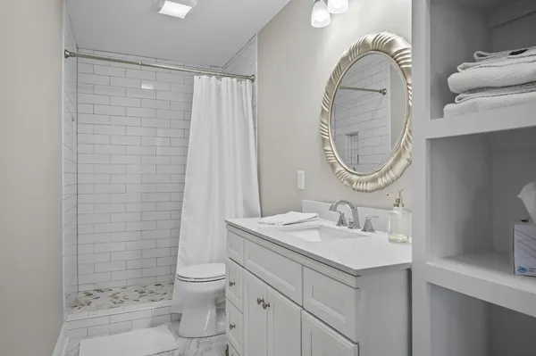 a bathroom with a sink a toilet and a mirror