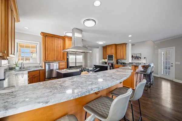 a kitchen with stainless steel appliances granite countertop a sink a stove and a refrigerator