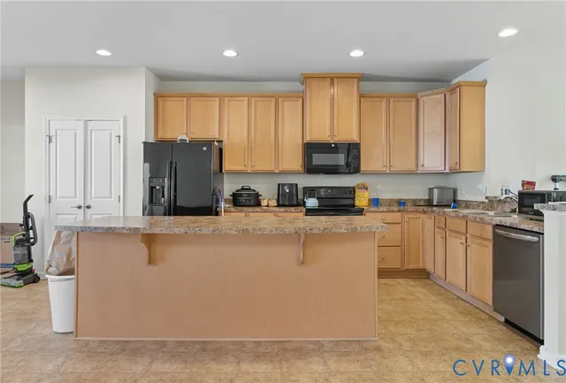 a kitchen with stainless steel appliances granite countertop a refrigerator a stove top oven a sink and dishwasher