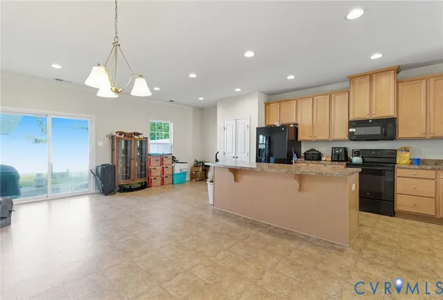 a large kitchen with cabinets chairs and a view of living room