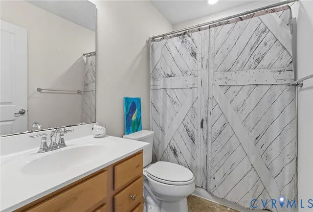 a bathroom with a sink a toilet and shower curtain