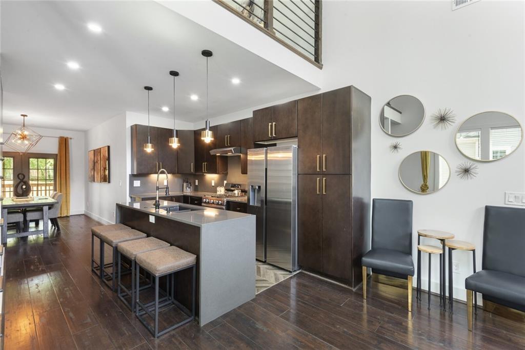 255 Mathewson Place Southwest Atlanta, GA 30314 - Photo 11 of 32 a kitchen with stainless steel appliances granite countertop a refrigerator a stove top oven a dining table and chairs with wooden floor