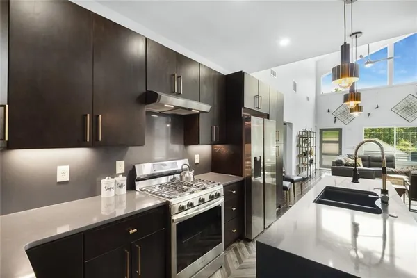 a kitchen with stainless steel appliances granite countertop a sink stove and refrigerator