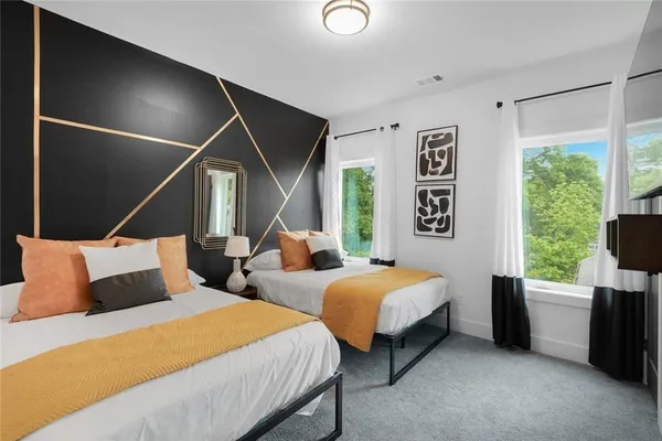 a bedroom with two beds and a large window