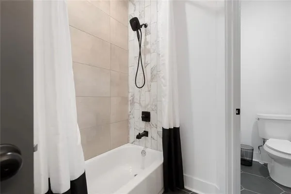 a bathroom with a bathtub a sink a toilet and a shower