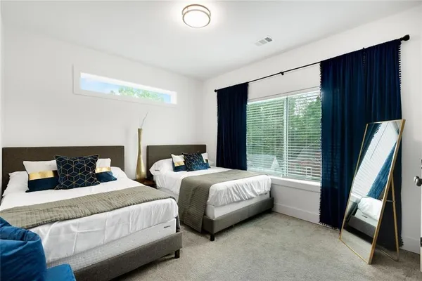 a bedroom with two beds and large window