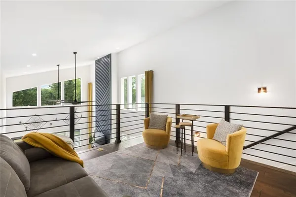 a balcony with chairs and a potted plant