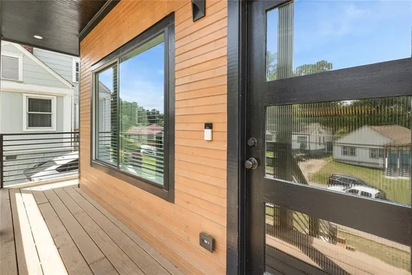 a view of a balcony with floor to ceiling windows with wooden floor