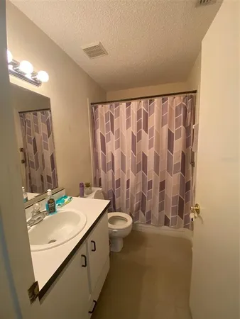 a bathroom with a granite countertop sink a toilet and a mirror