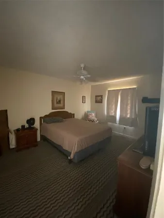a bedroom with a bed flat screen tv and window