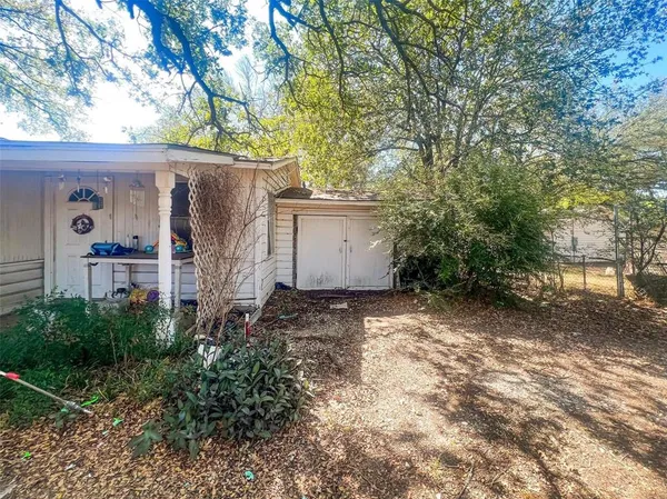 a view of a house with a tree in the backyard