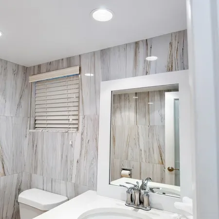 a bathroom with a granite countertop sink a toilet and shower
