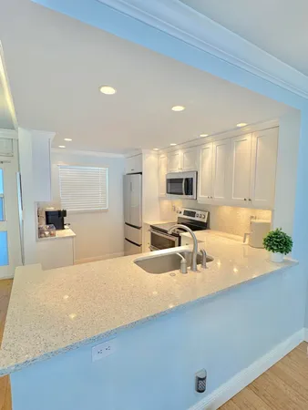 a large kitchen with kitchen island a sink stainless steel appliances and a counter top space