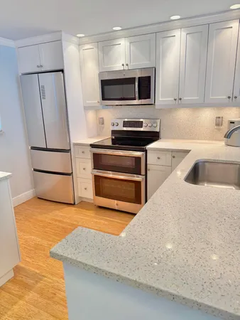 a kitchen with stainless steel appliances a stove a sink and a refrigerator