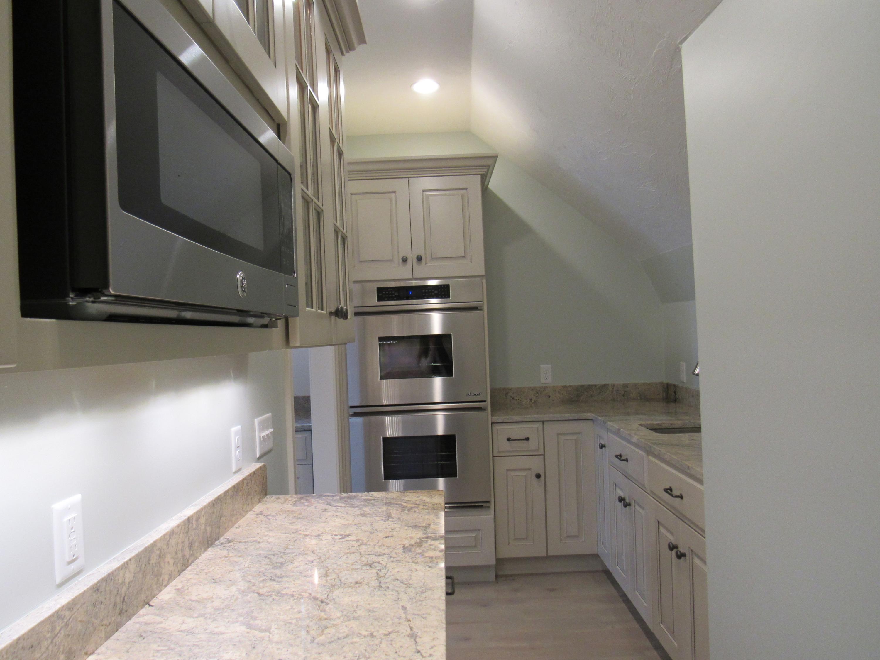 49-55 Rocky Point Road Bourne, MA 02532 - Photo 12 of 42 a kitchen with white cabinets and stainless steel appliances