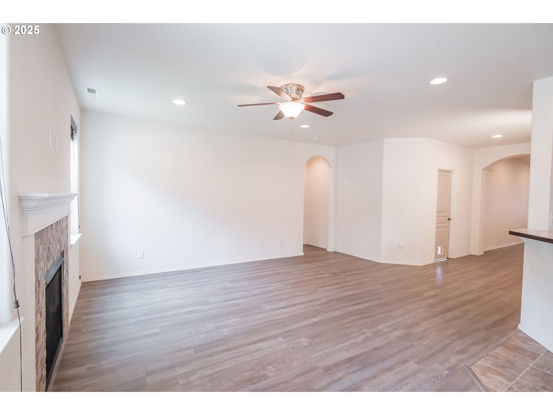 1067 South 55th Street Springfield, OR 97478 - Photo 4 of 35 a view of an empty room with wooden floor and a ceiling fan