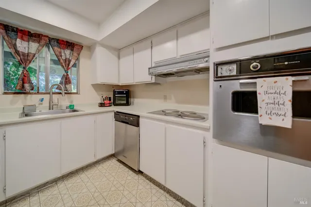 a kitchen with stainless steel appliances white cabinets and a refrigerator