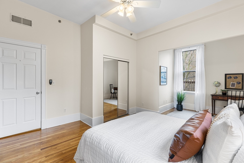 398 Broadway, Unit 2A Somerville, MA 02145 - Photo 11 of 25 a bedroom with a bed and wooden floor