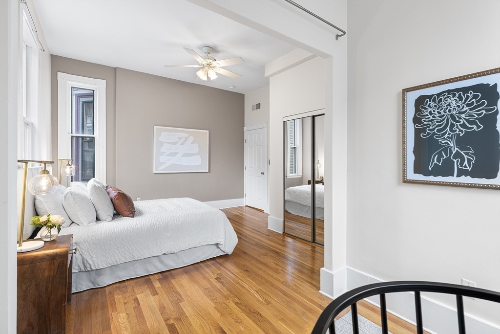 398 Broadway, Unit 2A Somerville, MA 02145 - Photo 13 of 25 a bedroom with a bed and wooden floor